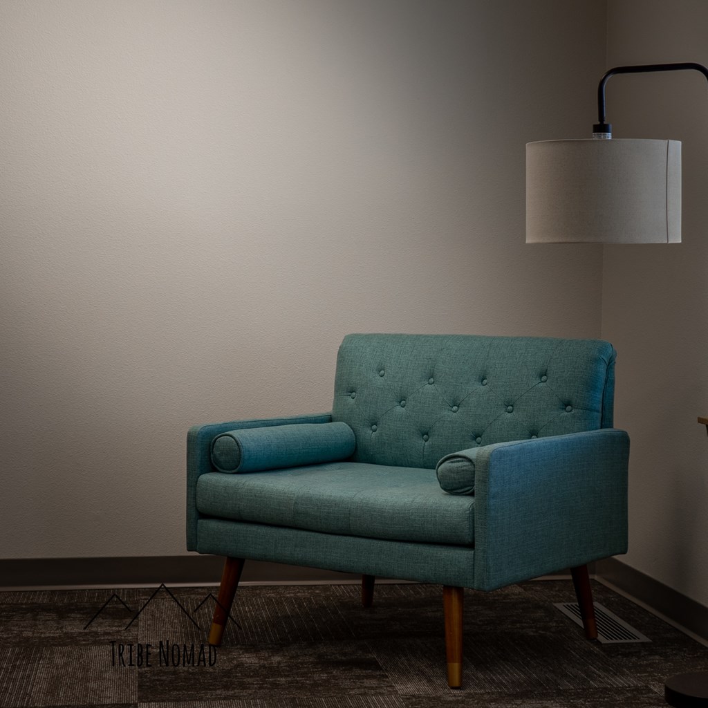 a blue chair in a room with a lamp