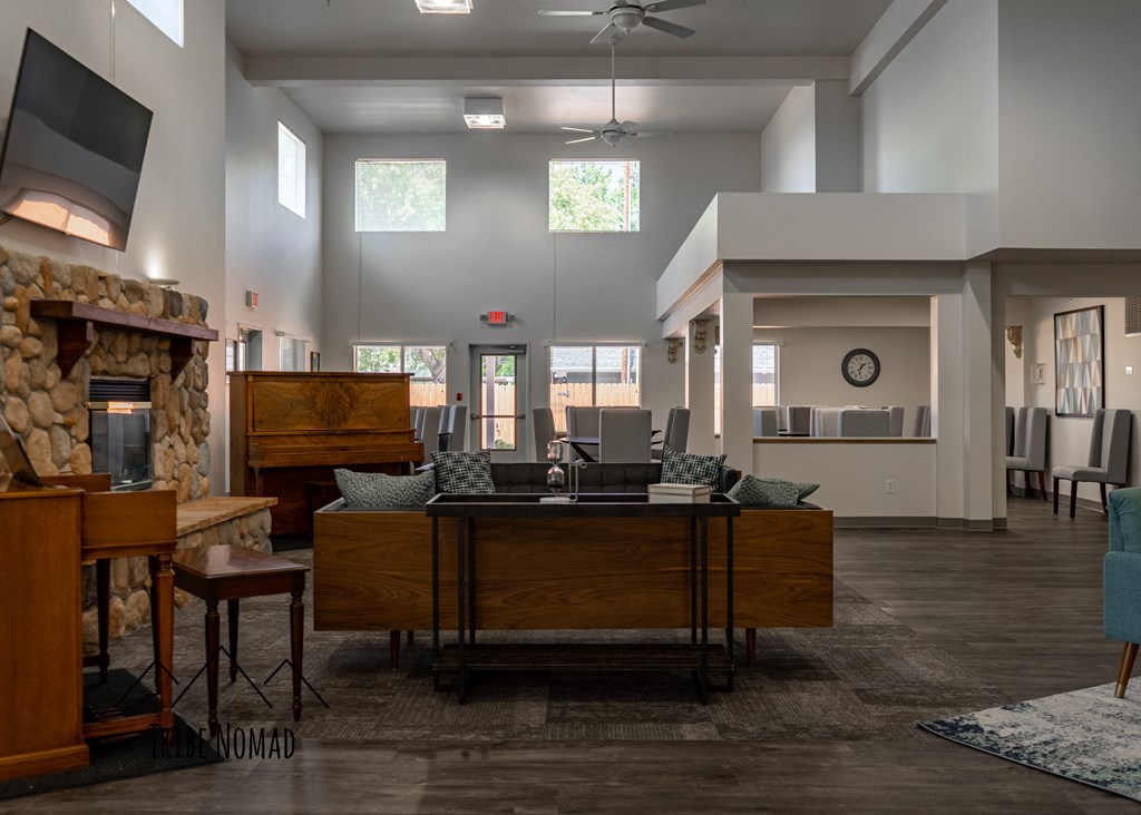 a large living room with a desk and a fireplace