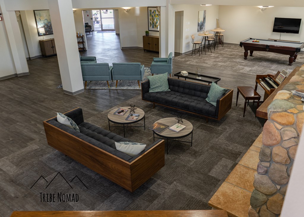 a living room with couches and tables and a pool table