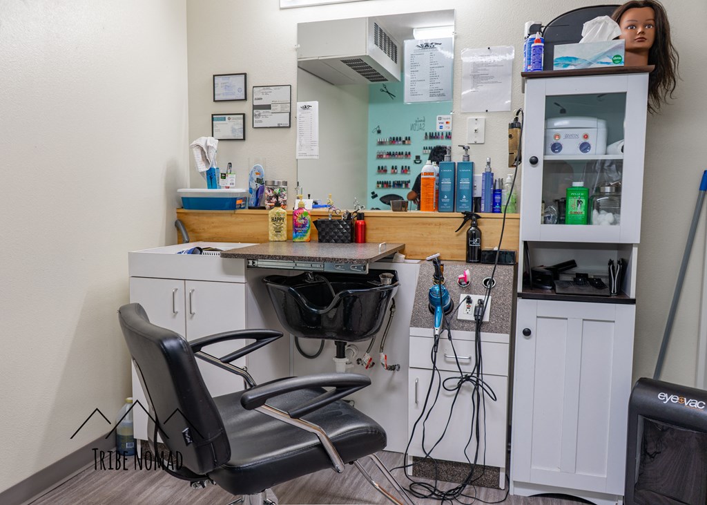 a woman sitting in a salon chair in front of a mirror