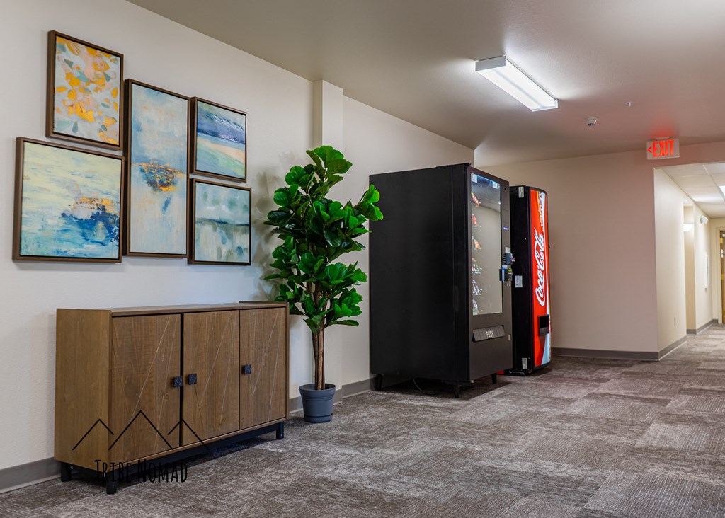 a lobby with a plant and a vending machine