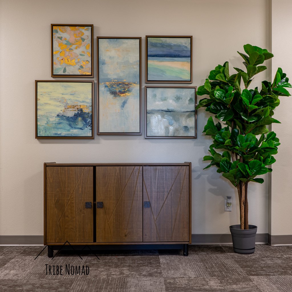 a plant in a room with art on the wall