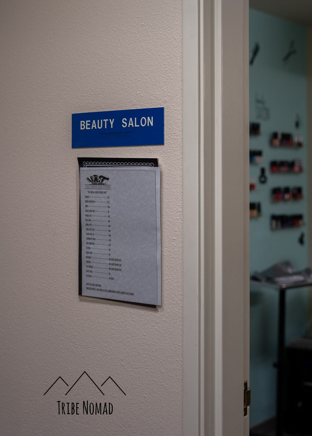 a beauty salon sign on a wall next to a door