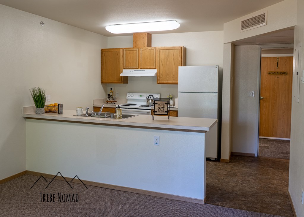 an empty kitchen with a counter and a refrigerator