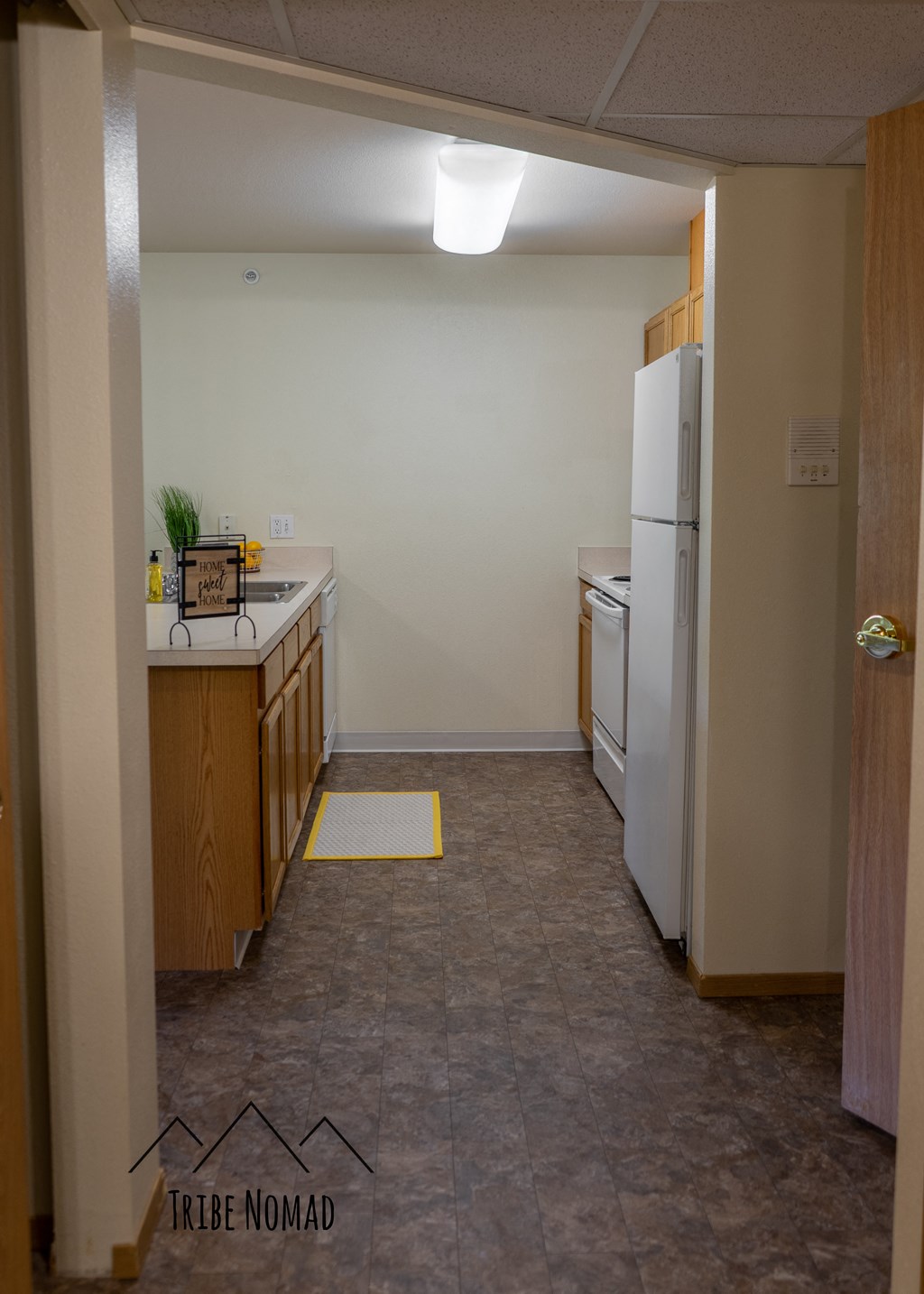 an empty kitchen with a white refrigerator and a sink