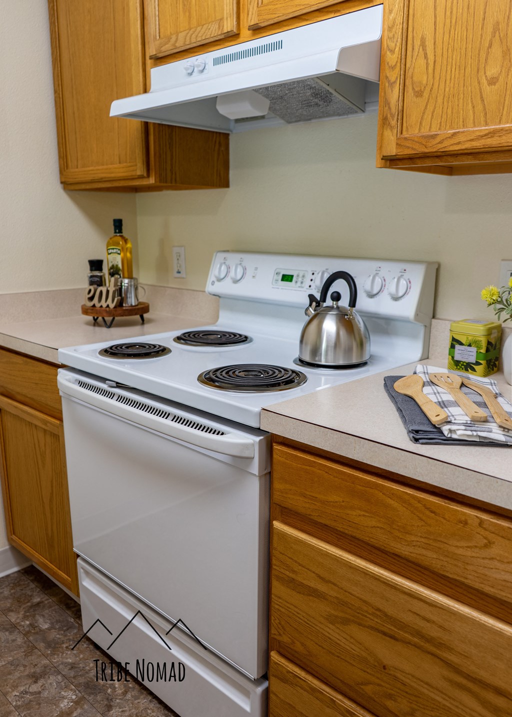 a kitchen with a stove and a kettle on top of it