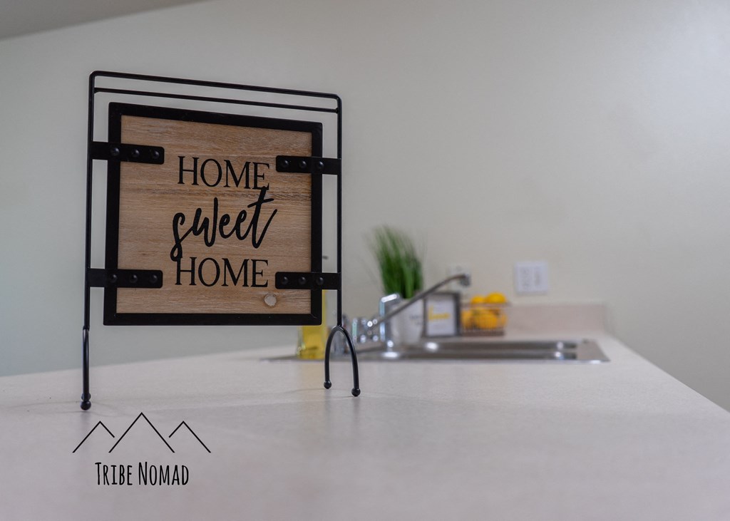 a kitchen counter with a sign that reads home sweet home