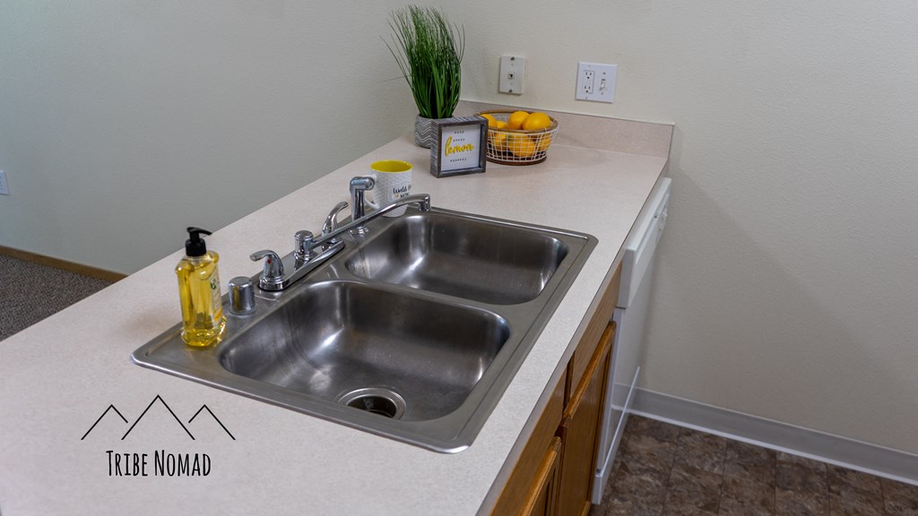 the kitchen has a stainless steel sink and counter top