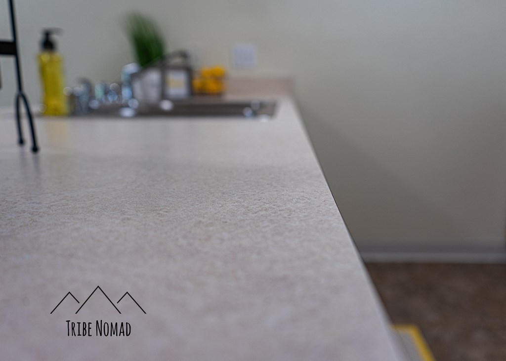a white counter top in a kitchen with a sink