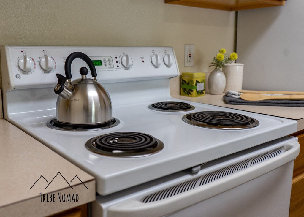 a white stove top oven with a tea kettle on top of it