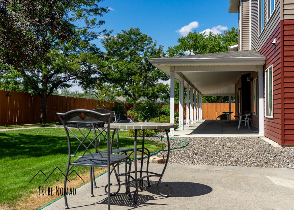 a patio with a table and chairs outside of a house