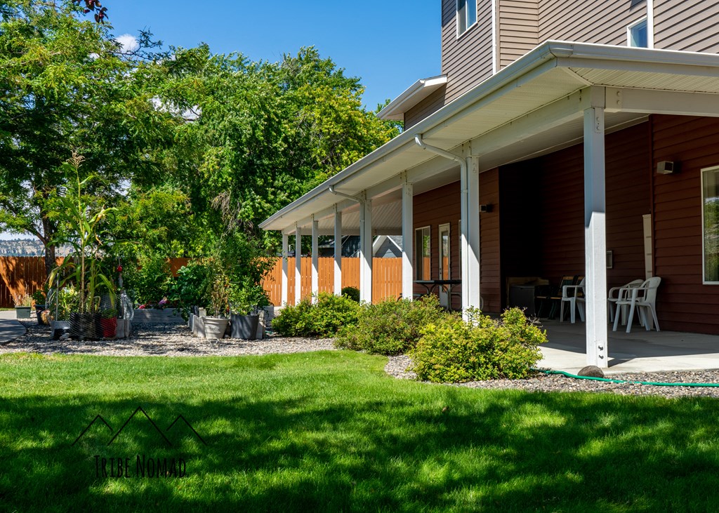 the front porch of a house with a lawn and a patio