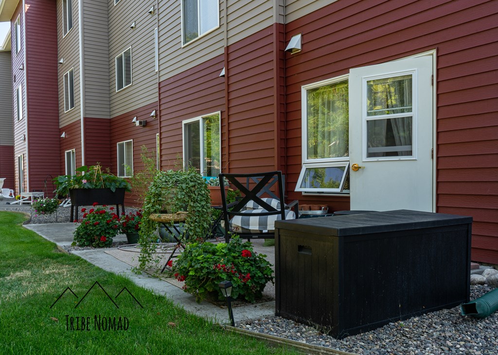 the outside of a red house with a hot tub and a porch