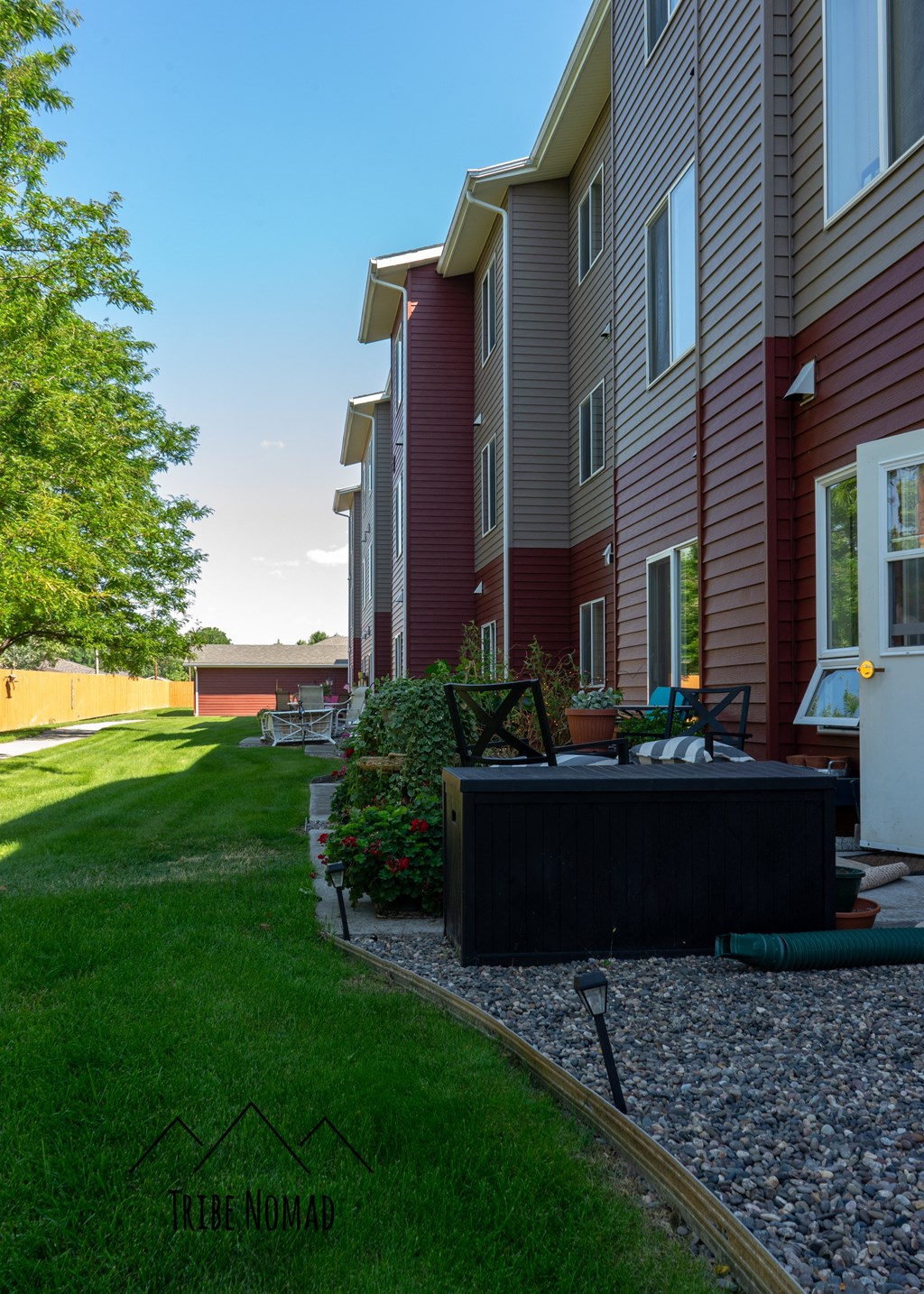 a backyard with a table and chairs in front of a house