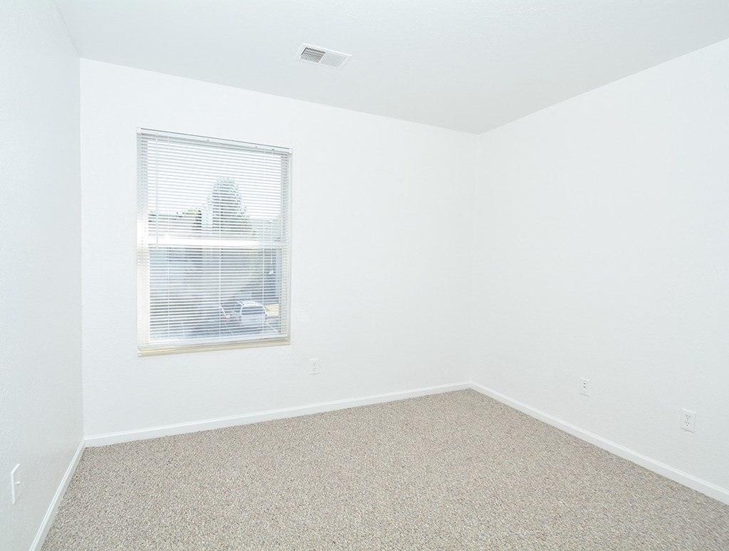 an empty room with white walls and a window
