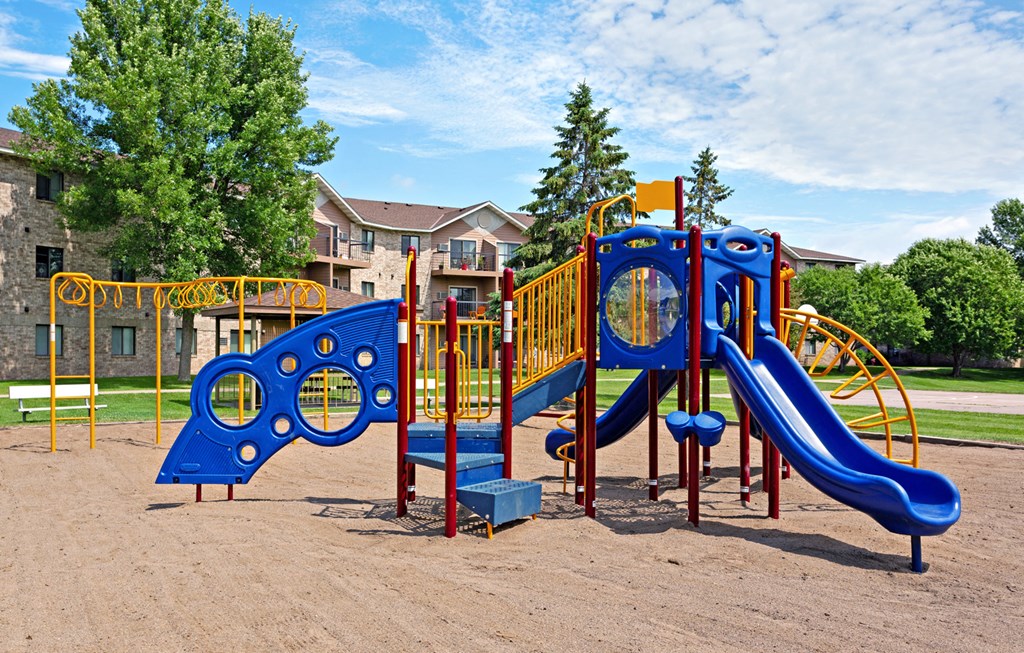 a playground with a blue and yellow swing set