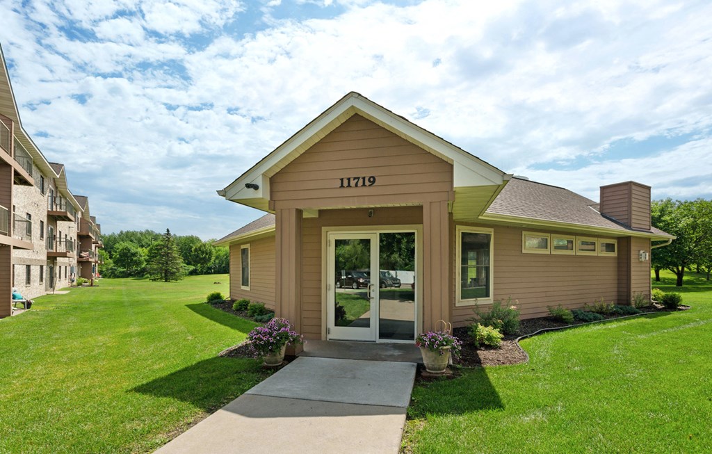 the view of the front of a house with a sidewalk and grass