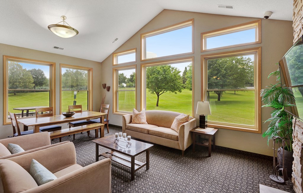 a living room with couches and tables and large windows