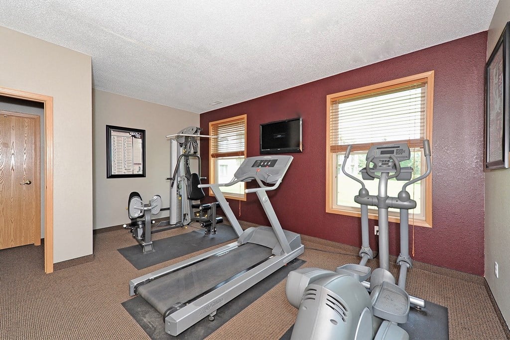 a gym with exercise equipment and a tv
