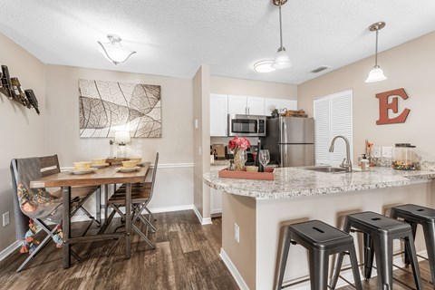 A kitchen with a table and chairs.