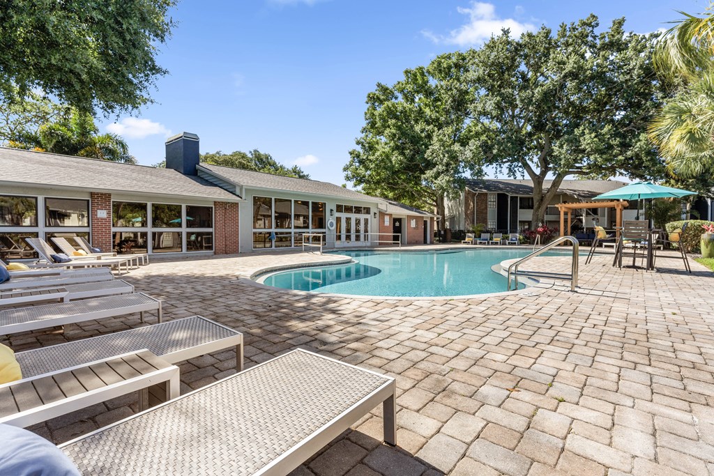 a swimming pool in front of a house with a resort style pool