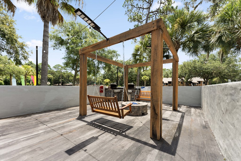 a swing bench in the backyard of a house
