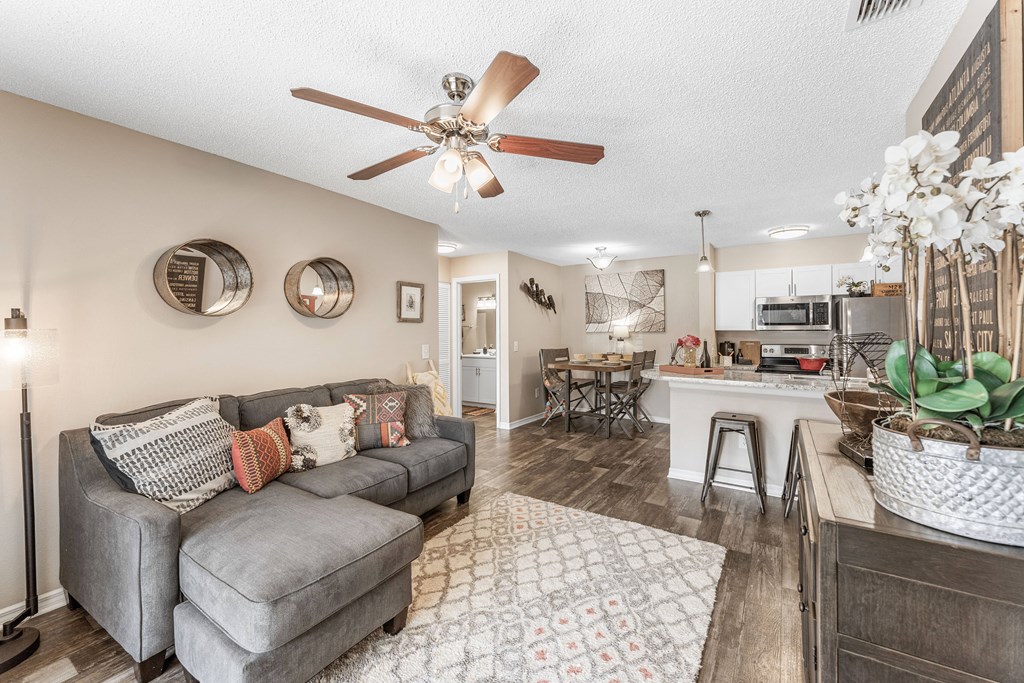 a living room with a couch and a ceiling fan