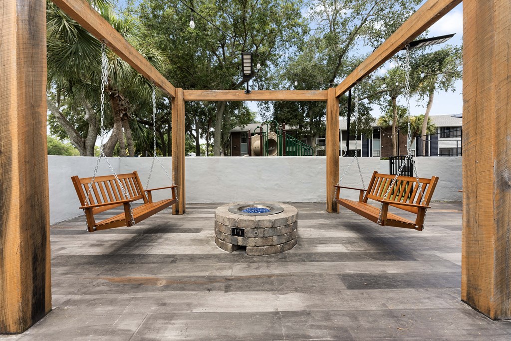 a fire pit in the middle of a patio with benches