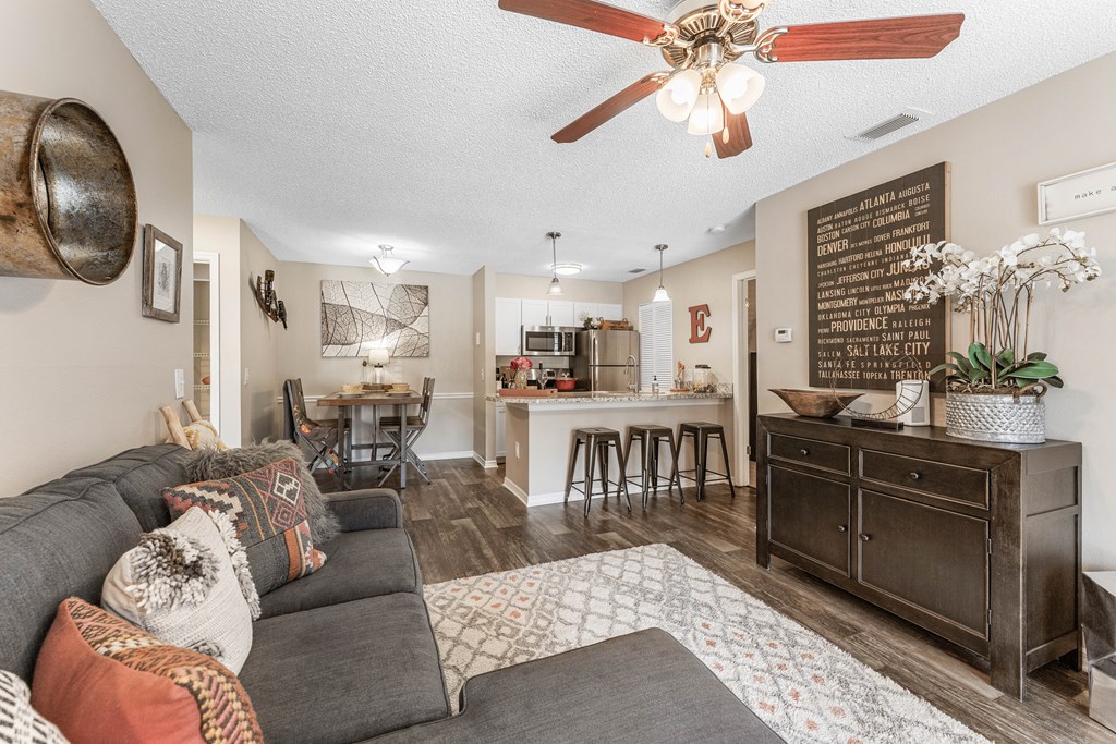 a living room with a couch and a kitchen in the background
