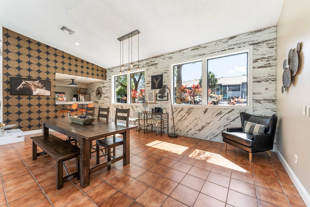 a dining room with a wooden table and chairs and a large window