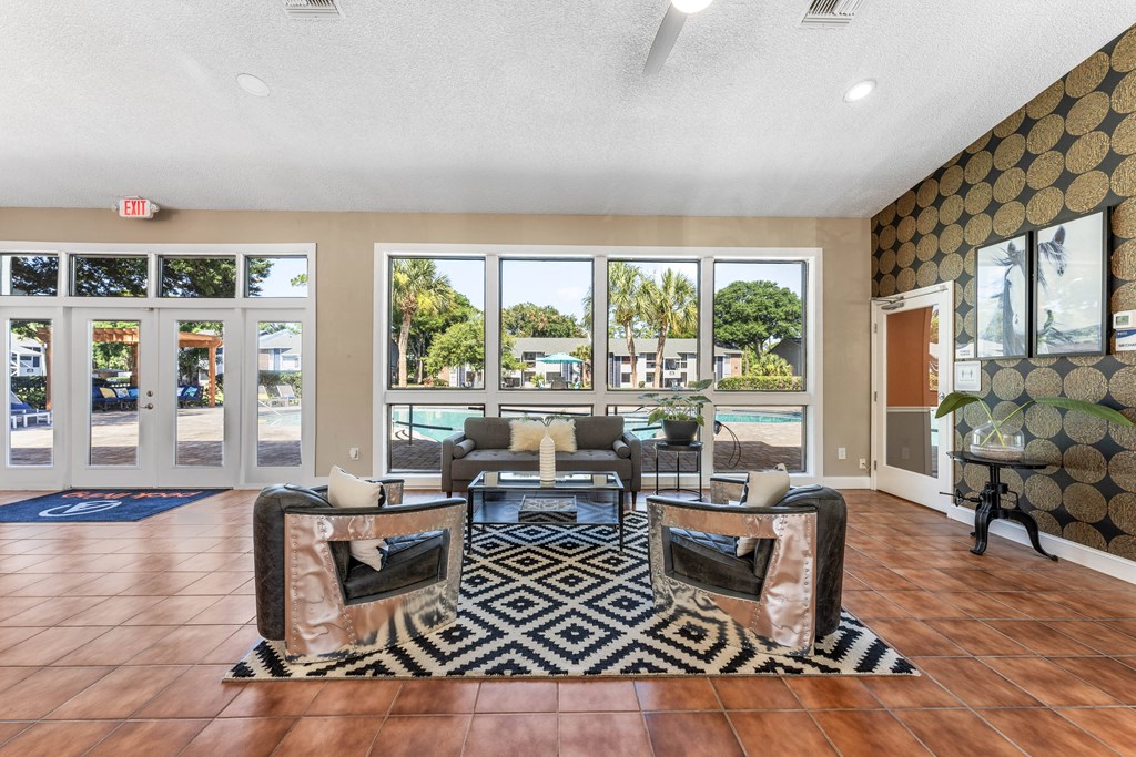 a living room with couches and chairs and a view of a pool