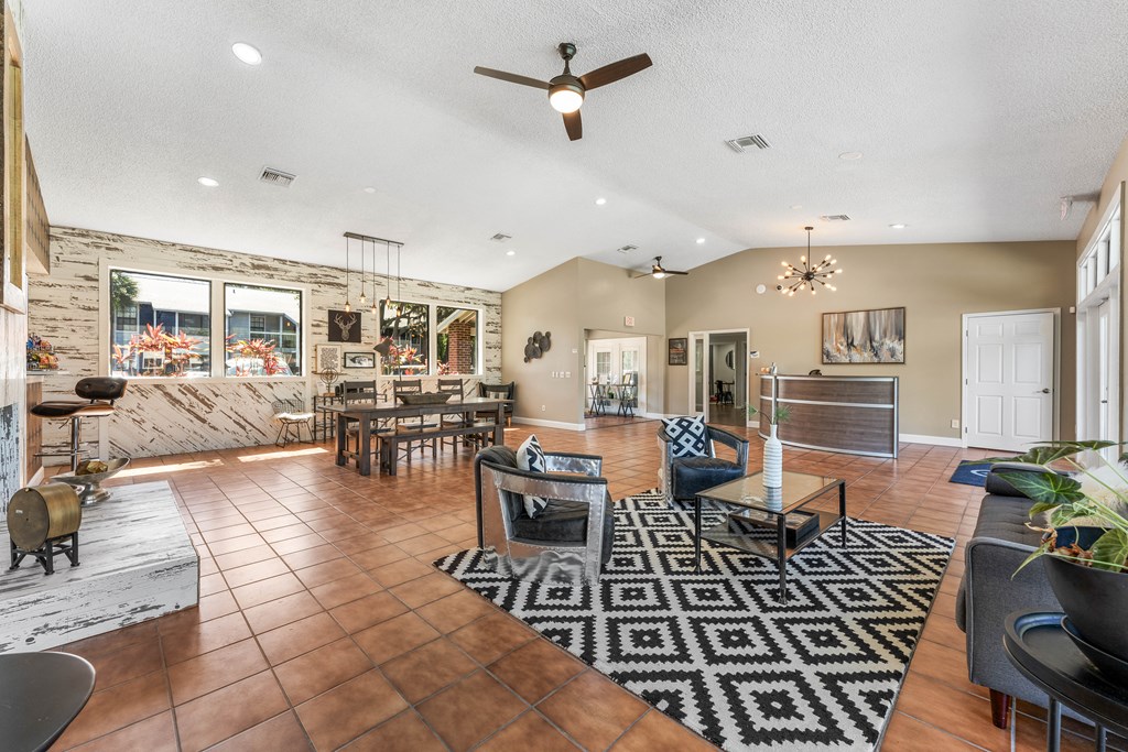 the living room and dining area of a house with a stone wall