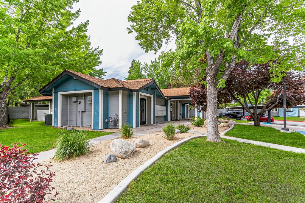 a group of houses in a row with trees and grass in front of them