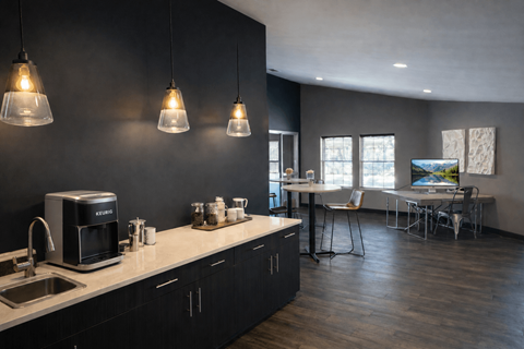 A kitchen with a black wall and a white counter top.
