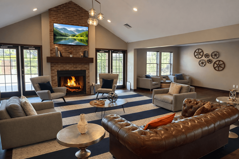 A living room with a fireplace and a television mounted above it.