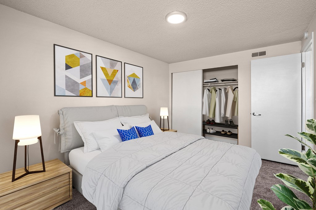 A bedroom with a large bed and a wooden nightstand.
