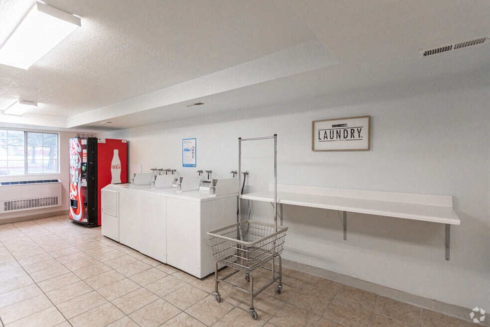 the laundry room is equipped with a large counter and a red coke machine