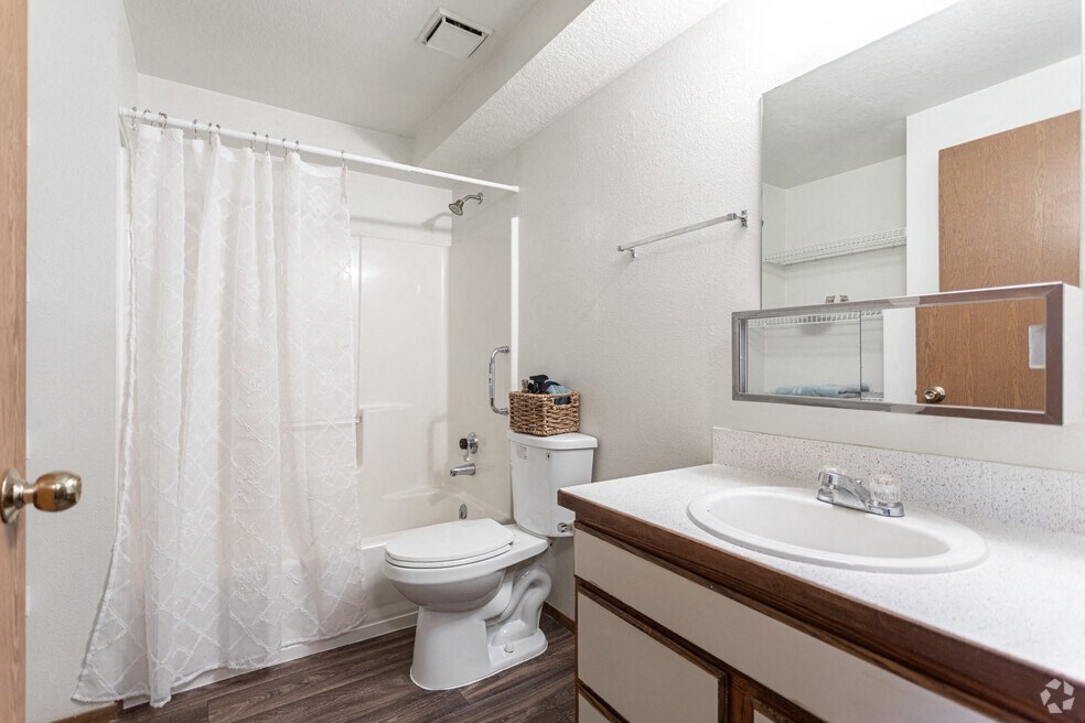 a bathroom with a toilet sink and shower and a mirror