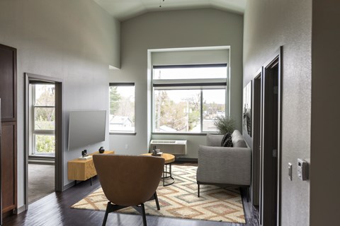 A living room with a brown chair and a grey couch.