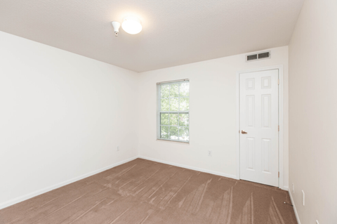 an empty room with white walls and a window and a door