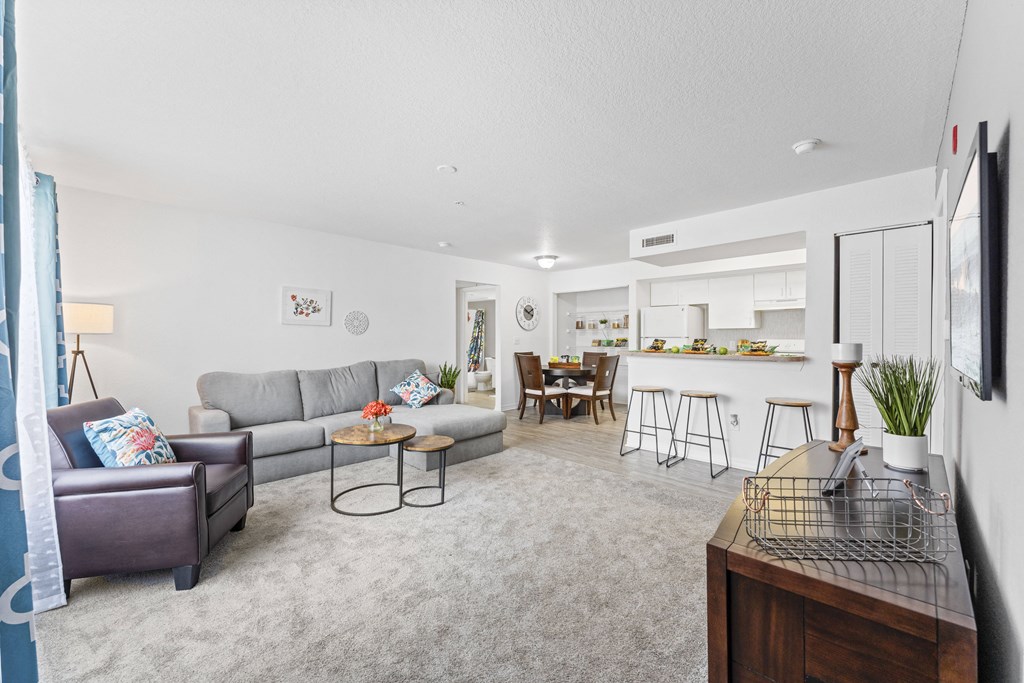 a living room with couches and a kitchen with a table and chairs