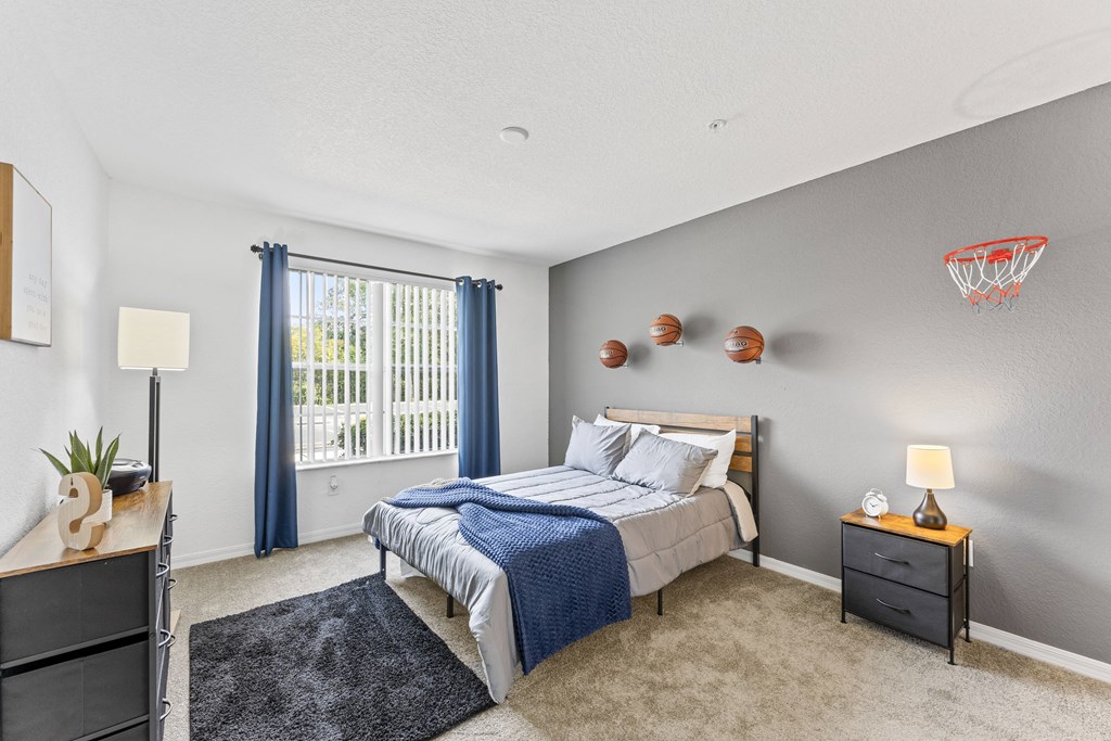 a bedroom with a bed and a window with blue curtains