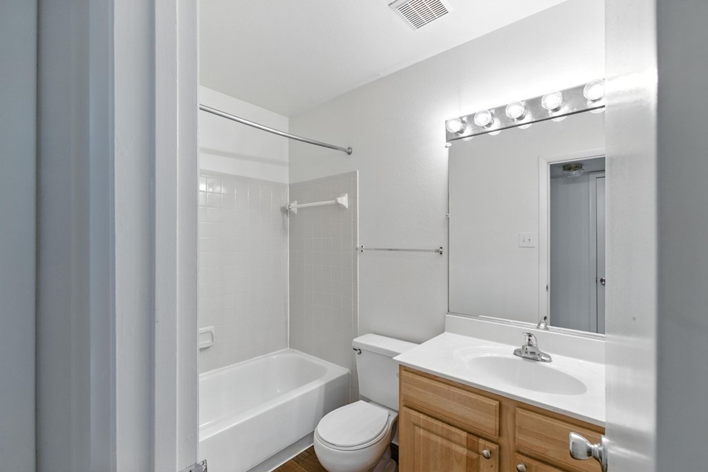 A white bathroom with a toilet, sink, and bathtub.