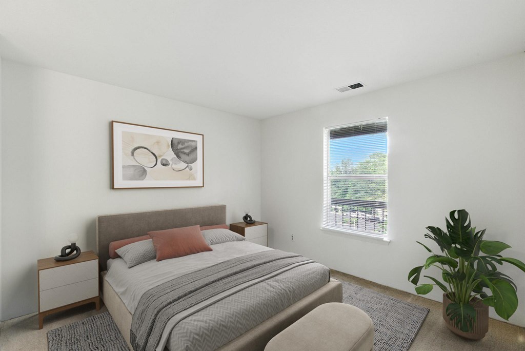 A bedroom with a bed, nightstand, and a plant.