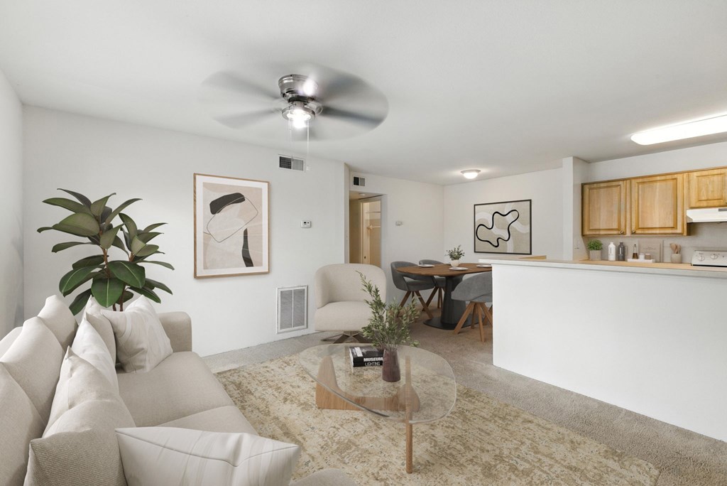A living room with a white couch and a glass coffee table.