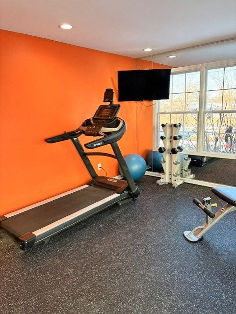 A treadmill is in a room with orange walls.