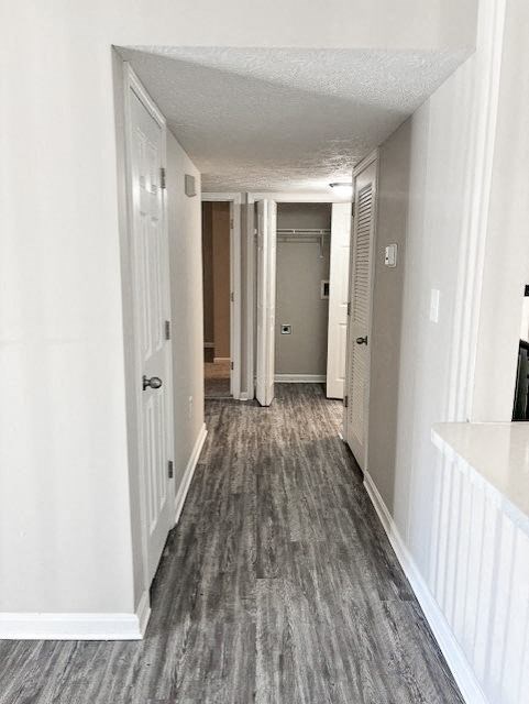A hallway with white walls and a grey carpet.
