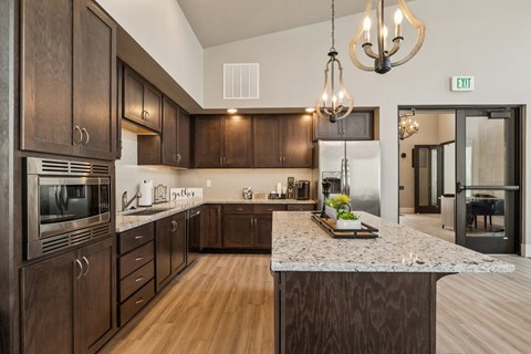 A kitchen with dark wood cabinets and a granite countertop.