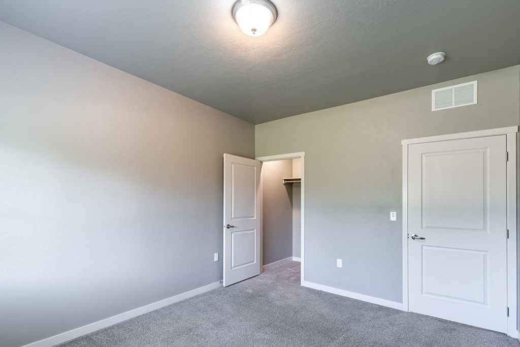 a bedroom with two doors and a closet