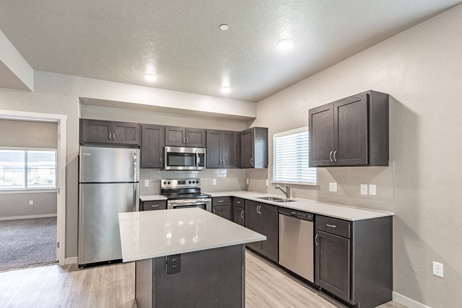a kitchen with a large island and stainless steel appliances